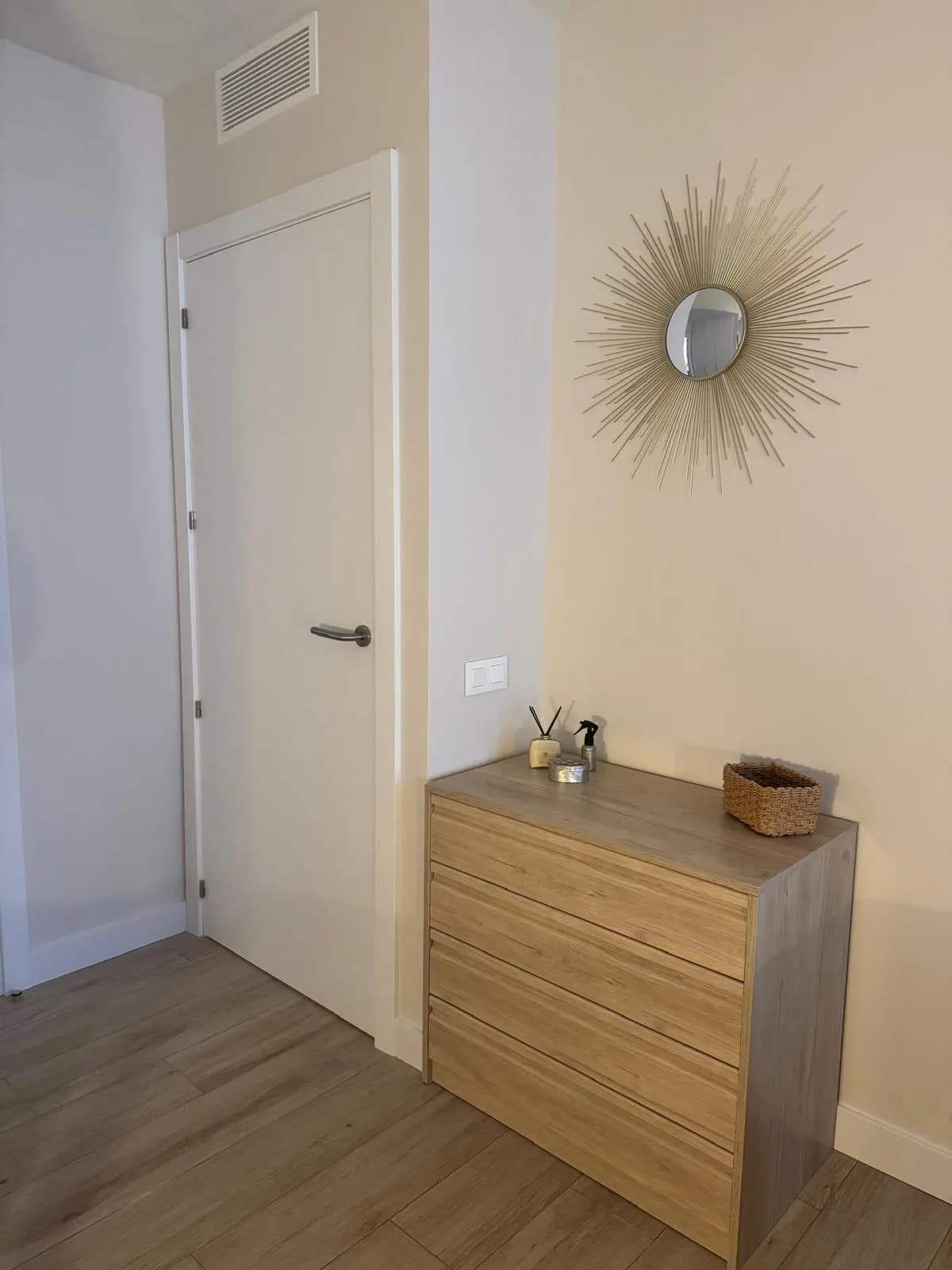 Slaapkamer met commode en ronde spiegel
